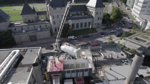 Crane lifting new boiler into powerhouse