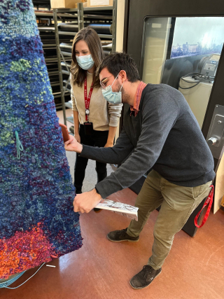 Michelle Macleod, Assistant Curator, and Alexis Janssen, VAC Intern, surveying tapestry, 2023