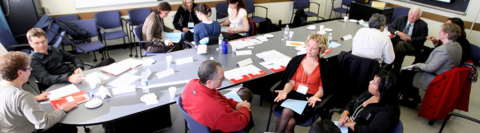 Students and staff sitting around a small conference room