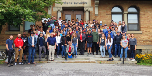 Students from all three years of the Farm Management and Technology diploma program stand with staff on the steps to the Raymond Building 