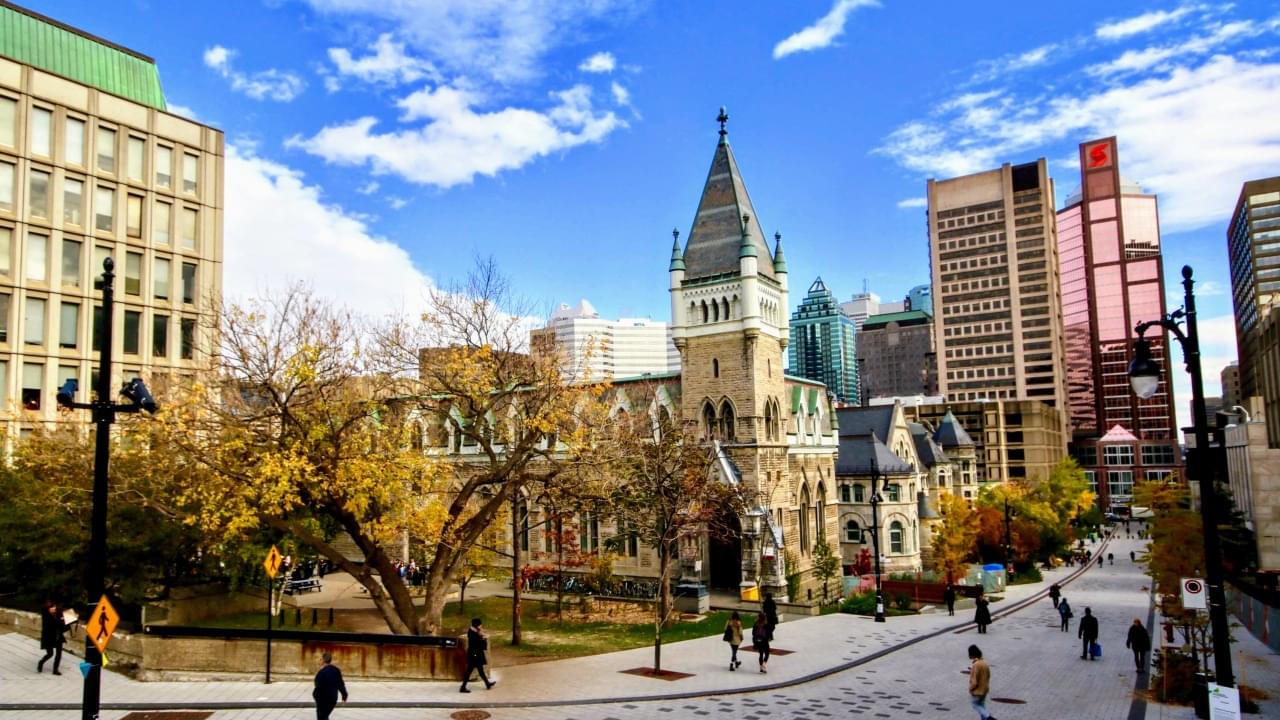 McGill buildings against a blue sky with clouds along McTavish Street, facing south east