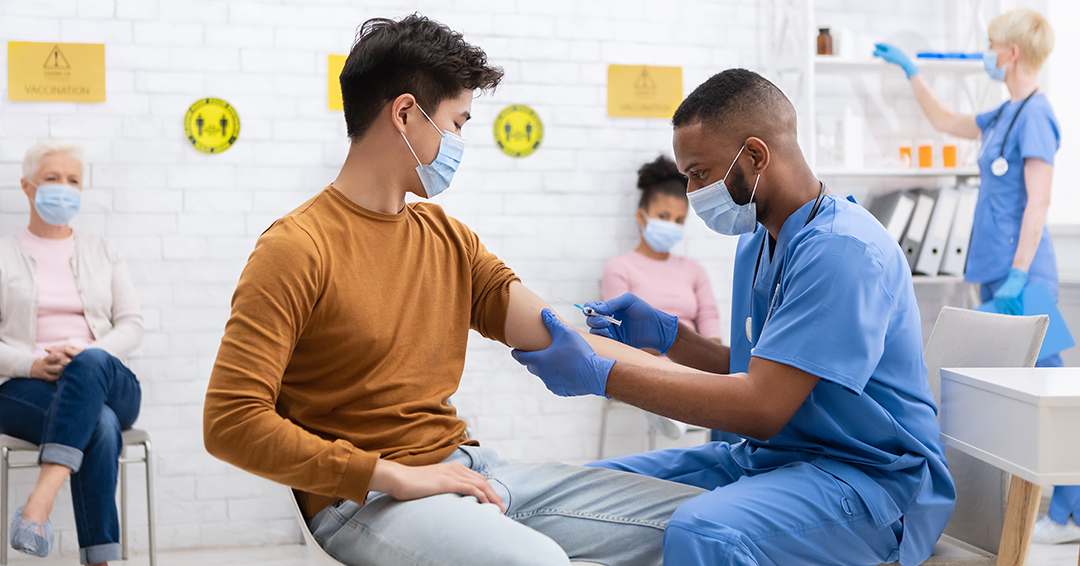 Young man getting COVID shot at clinic.