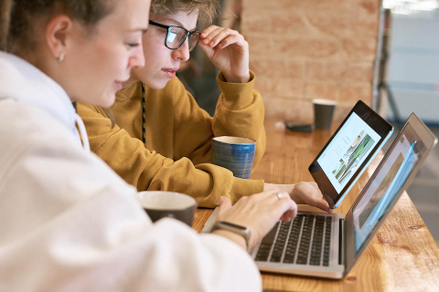 Two students looking at their laptops