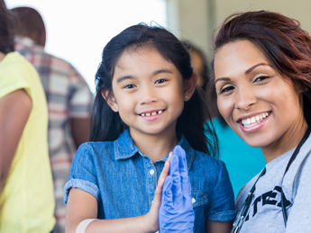 young Asian girl high-fiving a black doctor