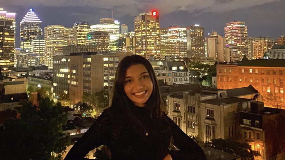 Hani Rukh-E-Qamar posing in front of downtown Montreal at night
