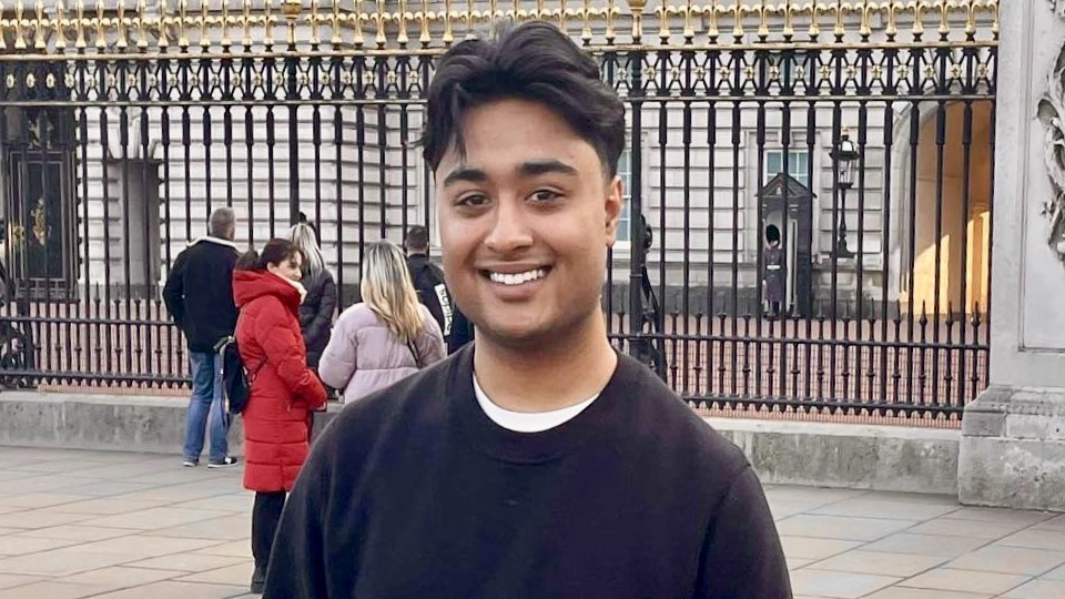 Simon Rahman - Young South Asian Man posing in front of a building