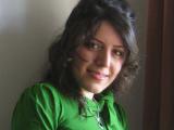 Belle jeune chercheuse, ingénieure iranienne. Chemise vert vif, cheveux bouclés, joli sourire