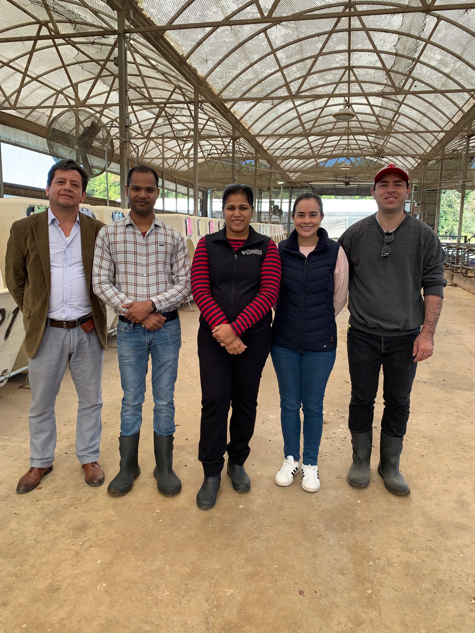 Student with his research team at dairy facility.