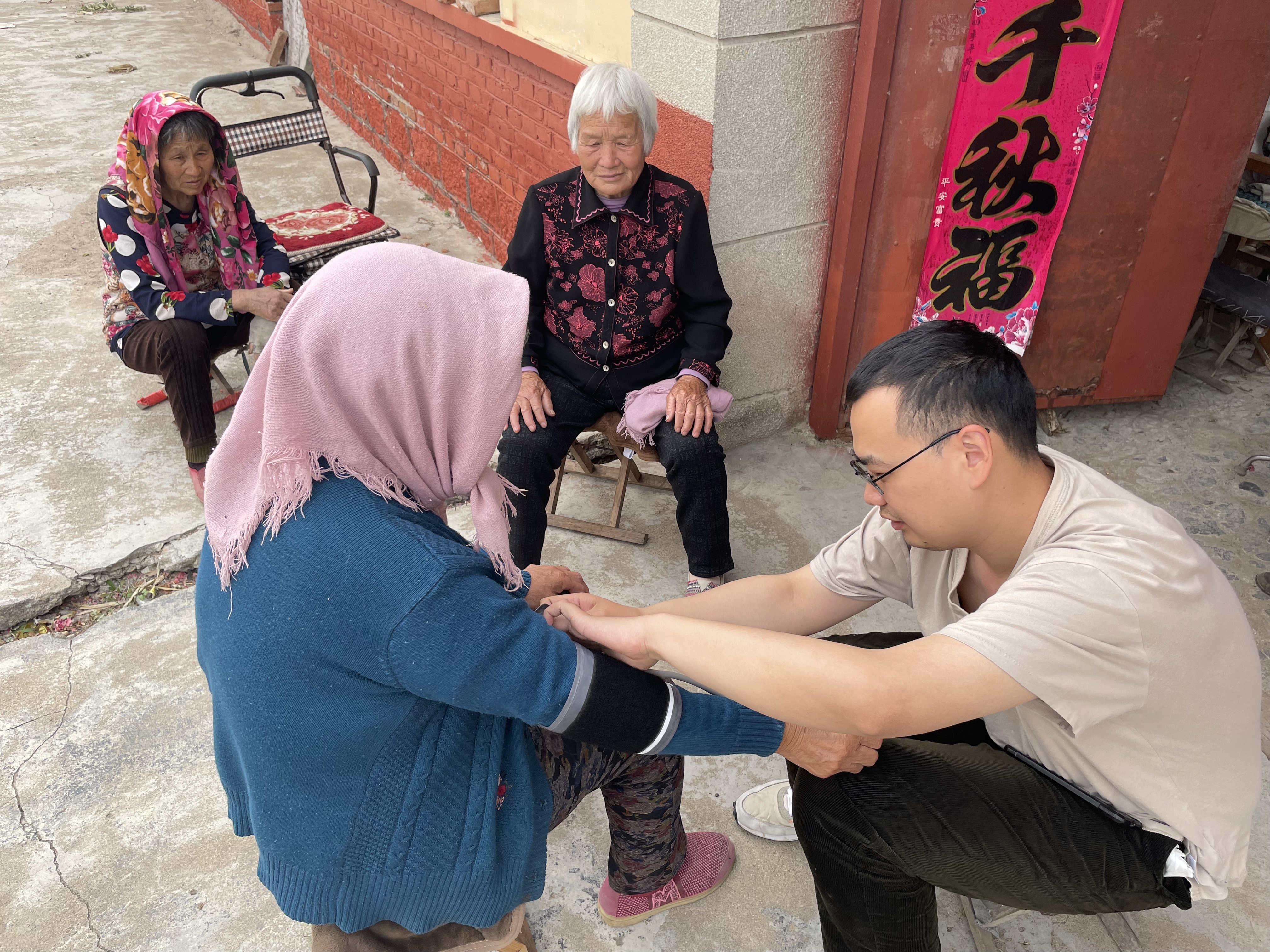 Ziyue Wang measuring the blood pressure of elderly villagers.