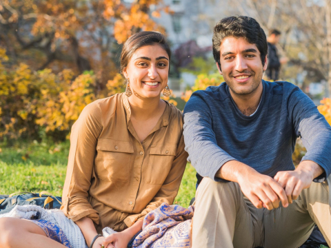 Students sitting on campus grounds in early Fall