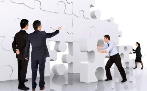 Group of people assembling a life-sized puzzle