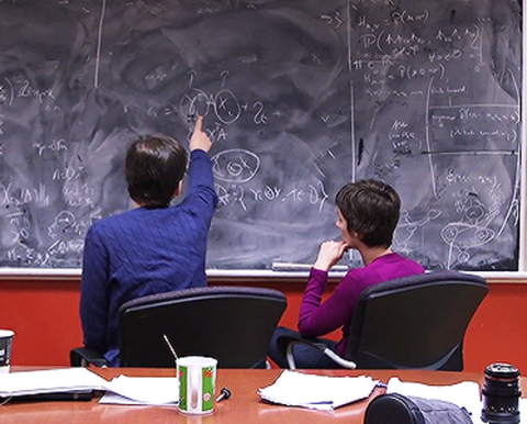 Professor Joelle Pineau with her supervisee discussing functions written on the blackboard