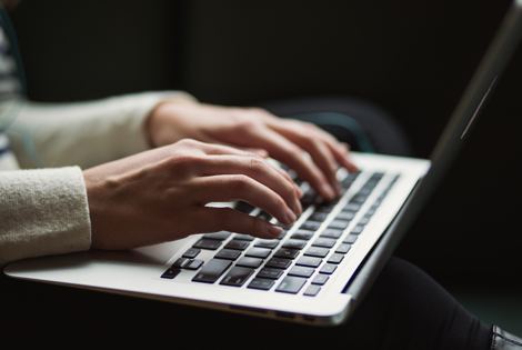 hands typing on a laptop computer