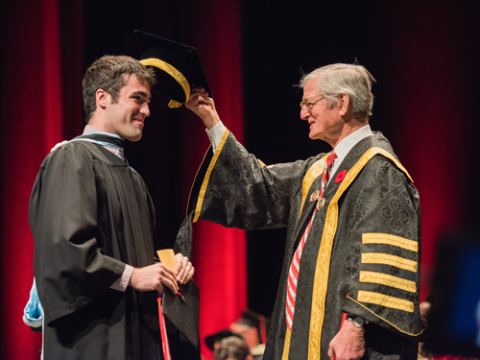 graduate being tapped on the head by chancellor