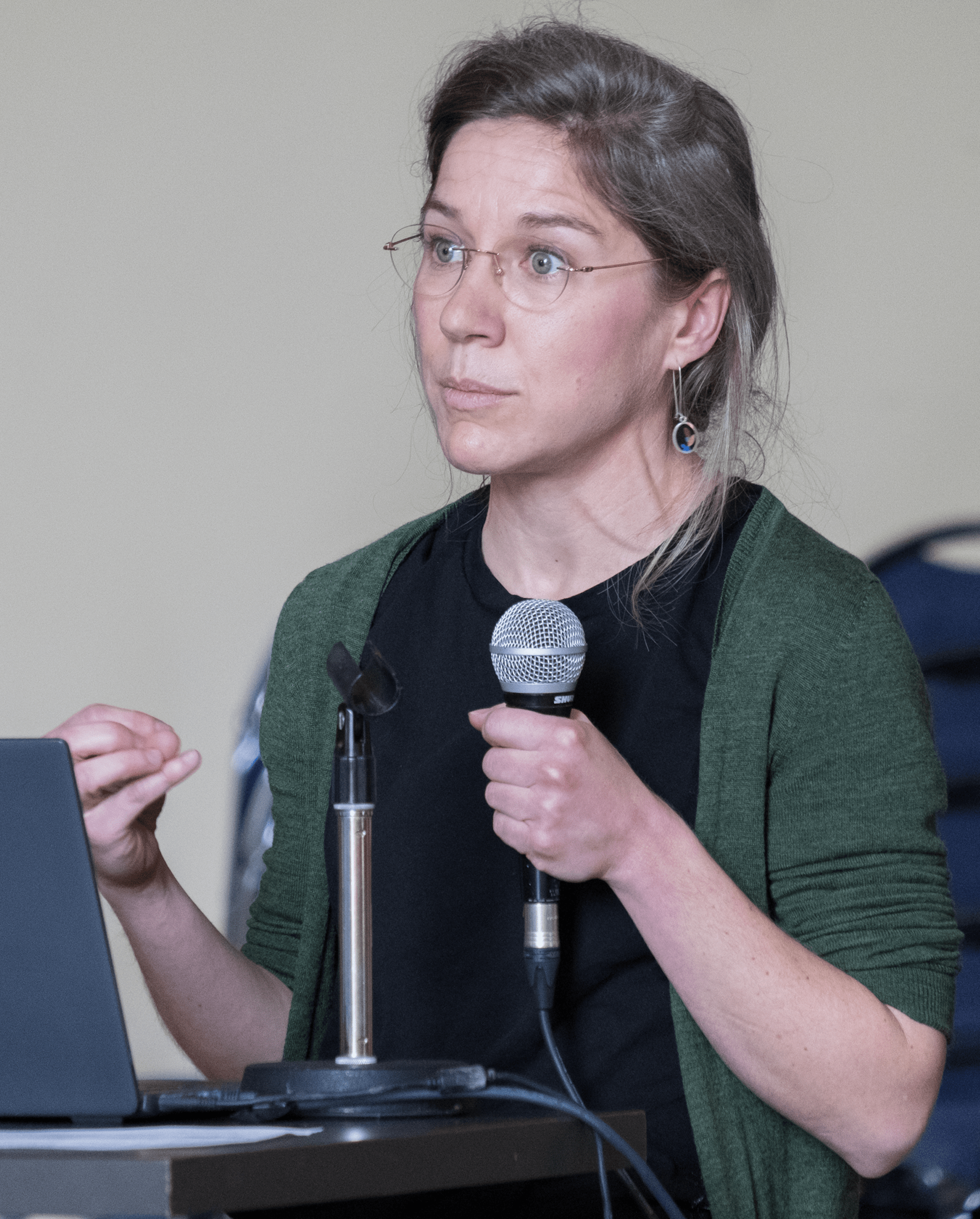 Madeleine Sharp holding microphone and speaking