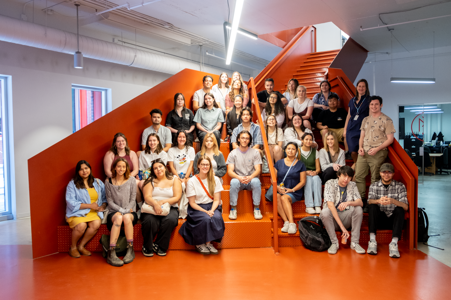 Two dozen students pose for group photo at Mila - Quebec AI Institute