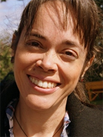 Headshot of Patricia Silveira, closely cropped and smiling at the camera outdoors.
