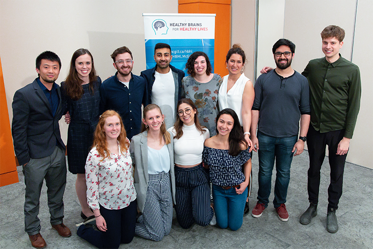 Group of trainee committee members posing in front of an HBHL banner