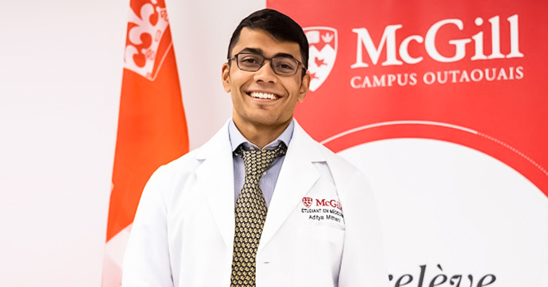 Adi Mithani wears a white coat with the McGill University logo and smiles.