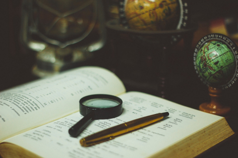 Book, magnifying glass, pen, globe, lamp