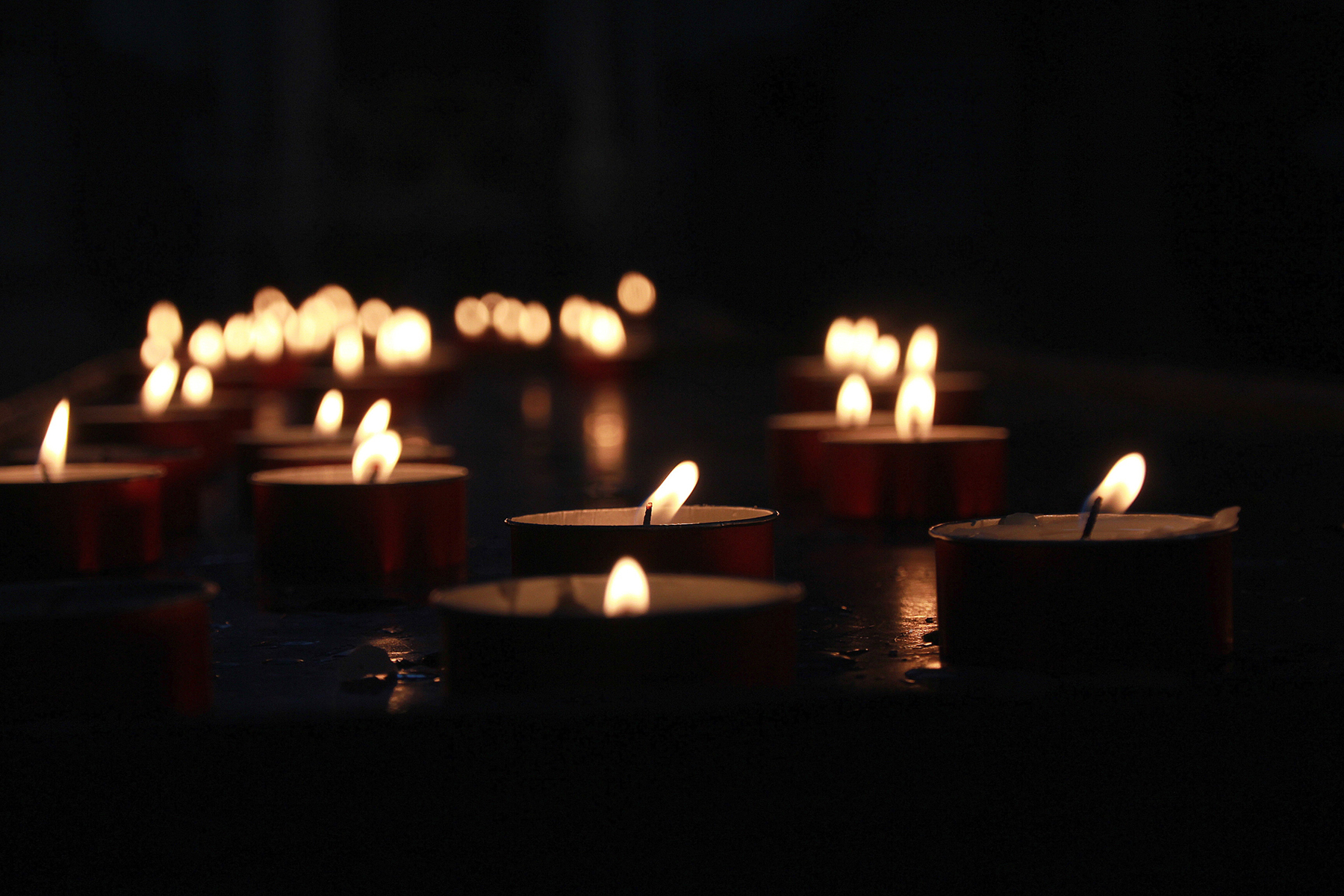 Votive candles illuminate the darkness