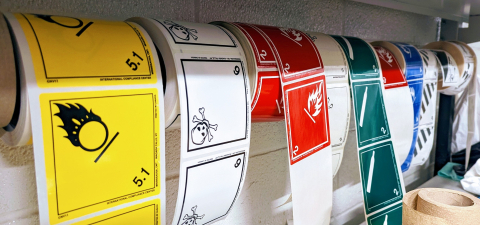 rolls of colourful stickers with hazardous waste symbols