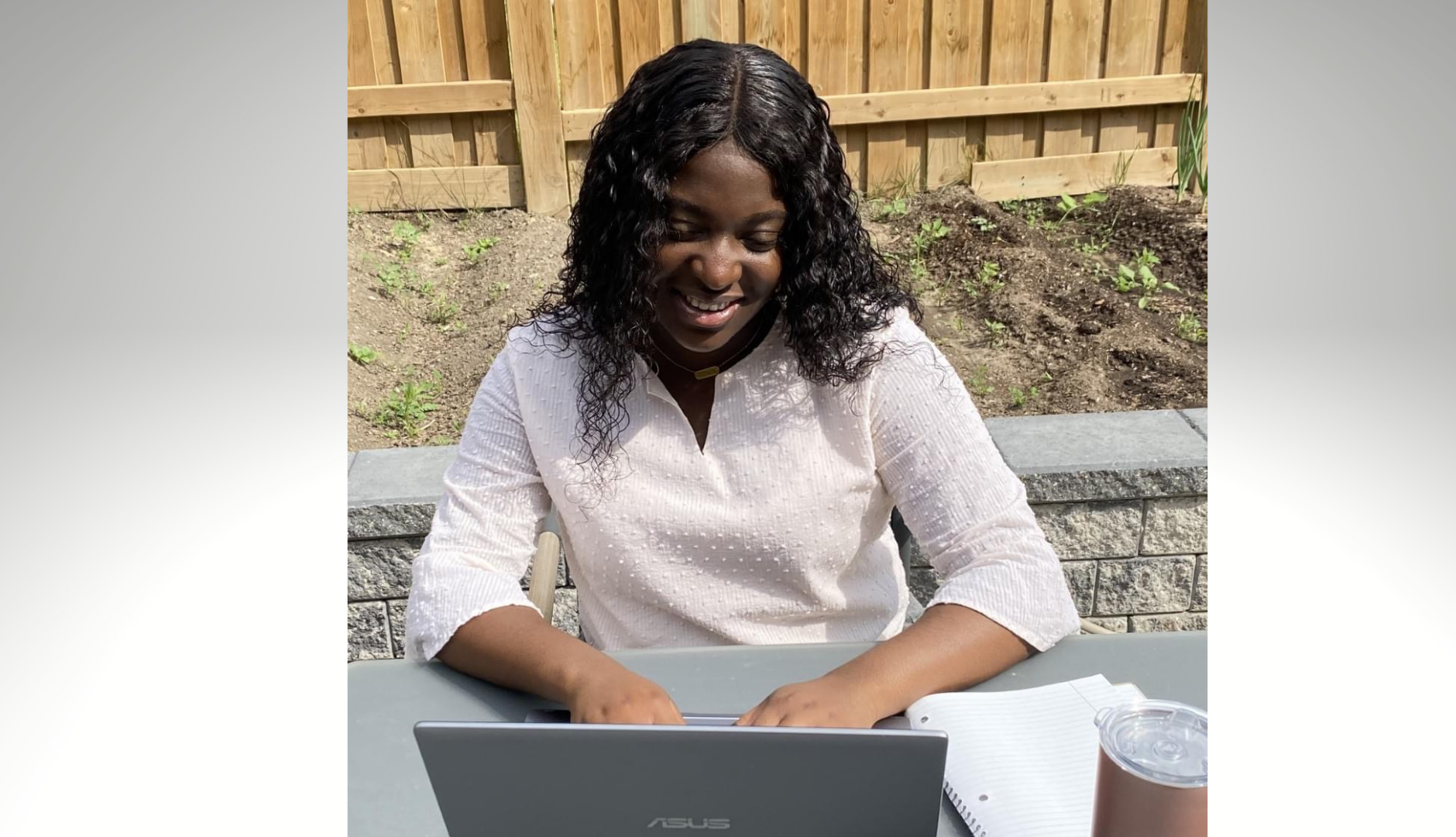 Eyitayo working from a desk outdoors