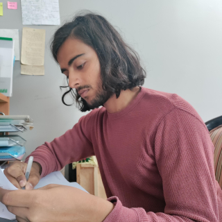 Samar Zia annotating a physical copy of his final report before submitting it to TU Freiberg.