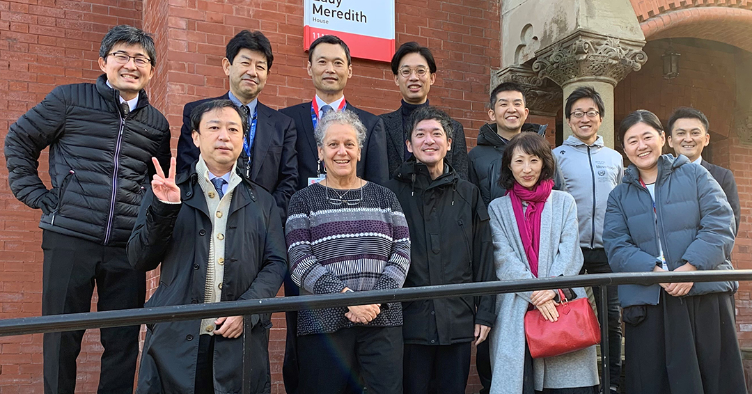 Linda Snell and a group of physicians from Gifu University in Japan smiling outside Lady Meredith House in Montreal, Canada