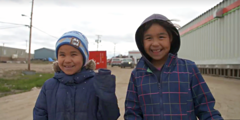 Two smiling young children dressed for cold weather