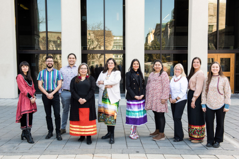 Group photo of the Office of Indigenous Initiatives team, featuring ten smiling individuals standing outside, side by side 