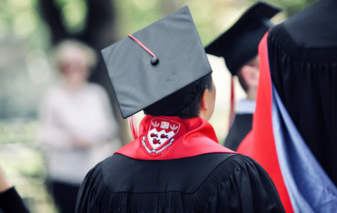 Une image d'un diplômé autochtone de McGill portant une casquette de graduation et un foulard rouge lors de la cérémonie du foulard