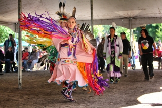 A photo of a dancer in pink regalia at a Pow Wow at McGill