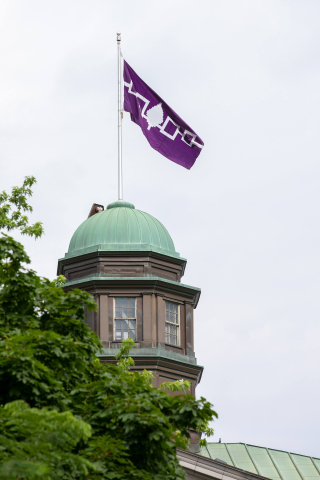 The Hiawatha Wampum Belt flag, a purple and white flag, flies on top of the Arts building at McGill University