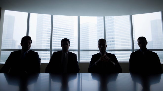 shadowy figures sitting at a table