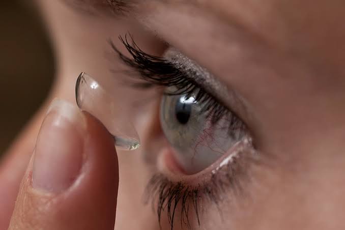 Woman putting in contact lense