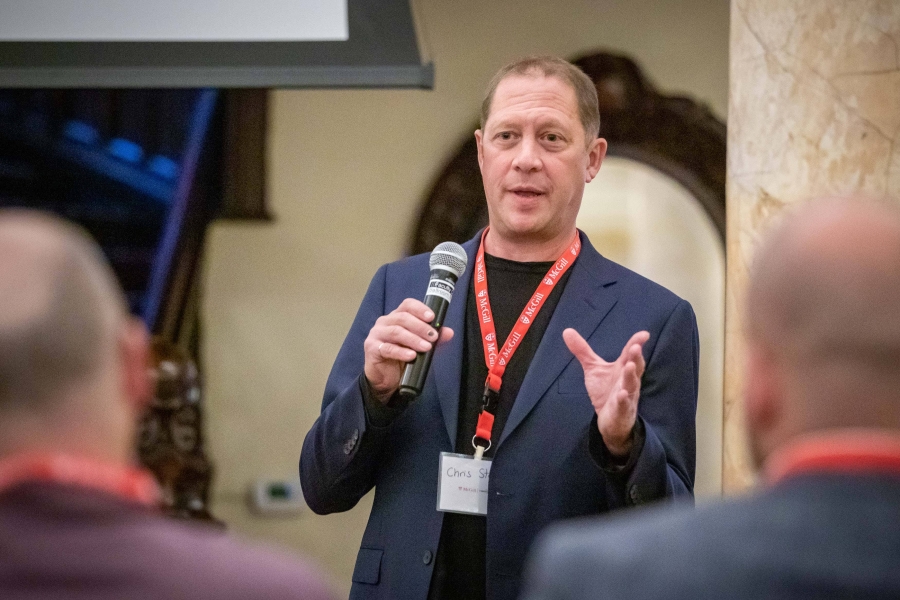 Man speaking at a microphone, raising hand