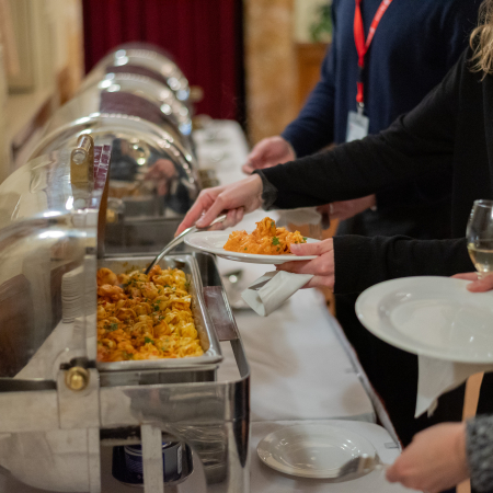 People serving themselves food from buffet trays