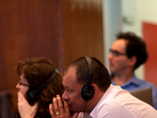 Chief Rodney Mark, Monica Mulrennan, and Eduardo Kohn listen to a presentation.