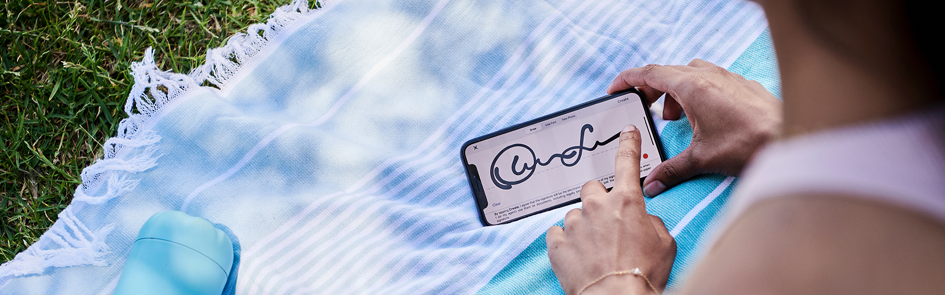 Woman signing a document with her mobile phone outdoors