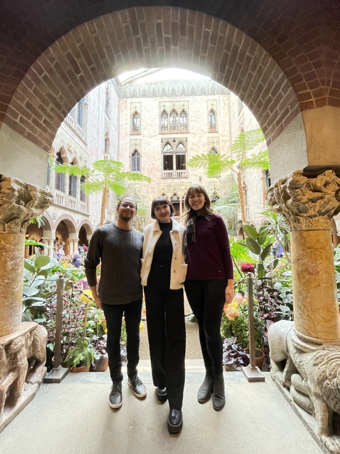 3 people standing underneath a stone archway