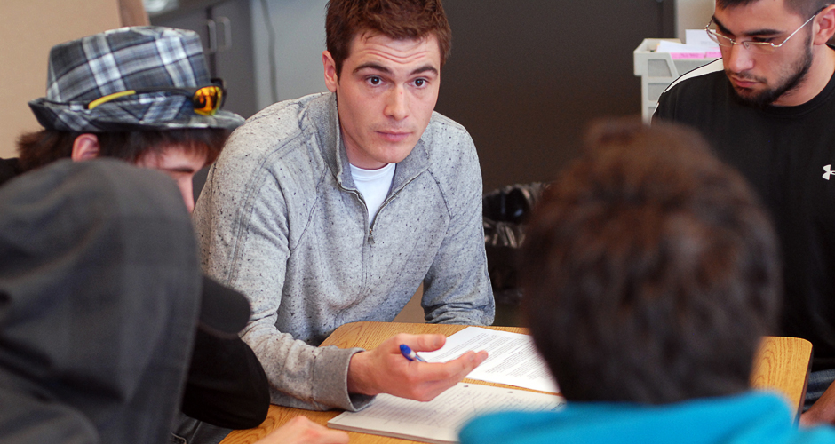 A law student in conversation with a group of highschoolers. 