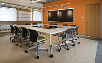 Office meeting room with a big conference table and several chairs surrounding it