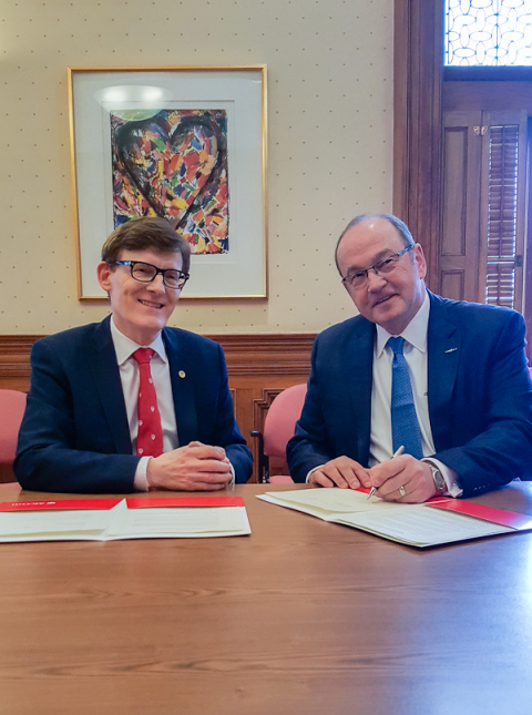 Professor Brian Havel and Captain Ron Abel signing the IASL/IFALPA internship agreement in the boardroom of the 3690 Peel street building at McGill, home of the Institute of Air and Space Law.