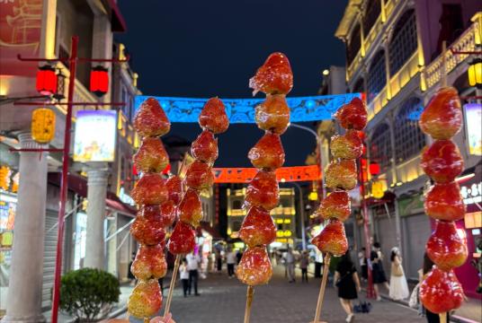 Students holding candied strawberries in the streets of Shantou city