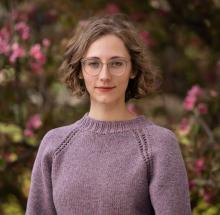 Headshot of Kristen wearing a lilac handknit sweater
