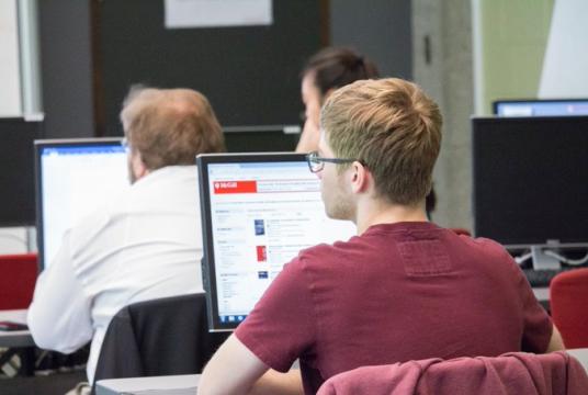 student listening to workshop with computer open in front of them
