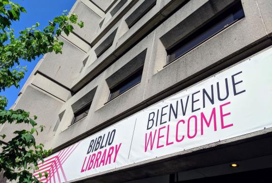 Exterior of the McLennan Library Building with a sign saying Bienvenue Welcome
