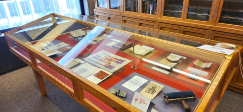 Installation view of exhibition in wood-paneled exhibition case.