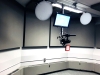 Screen and camera/ microphone hanging from ceiling in middle of One Button Studio.